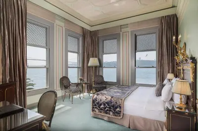 a bedroom with a bed and a desk and windows at Bosphorus Palace Hotel in Istanbul