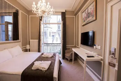 a bedroom with a bed and a desk and a television at Triada Hotel Taksim - Special Category in Istanbul