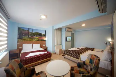 a hotel room with two beds and a table and chairs at Hotel Akcinar in Istanbul