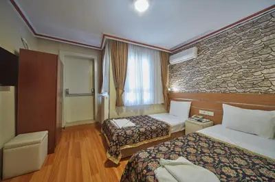 a hotel room with two beds and a stone wall at Hotel Akcinar in Istanbul