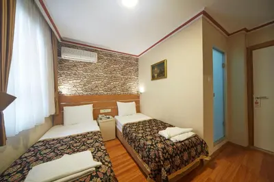 a hotel room with two beds and a stone wall at Hotel Akcinar in Istanbul