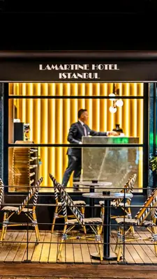 a man walking past a table in front of a building at Lamartine Hotel in Istanbul