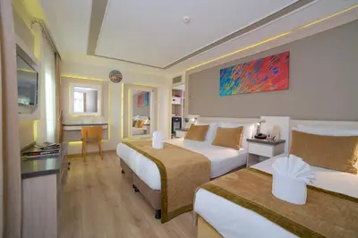 a hotel room with two beds and a desk at Hotel Bulvar Palas in Istanbul