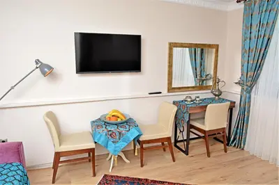 a living room with a table and chairs and a tv at Sphendon Hotel in Istanbul
