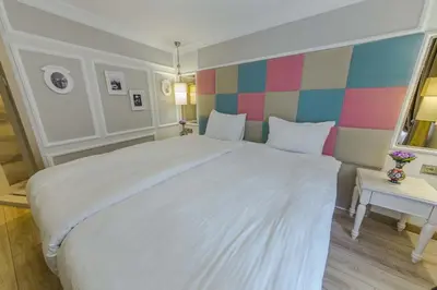 a bedroom with a large white bed and a colorful wall at The Constantine Hotel in Istanbul