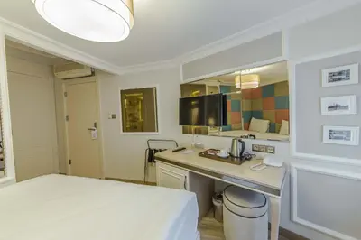 a room with a bed and a desk and a kitchen at The Constantine Hotel in Istanbul