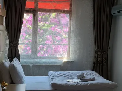 a bedroom with a bed and a window with pink flowers at Oceans 7 Hotel in Istanbul