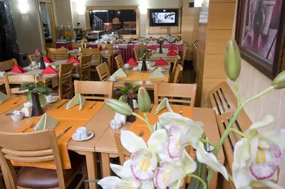 a restaurant with wooden tables and chairs and flowers at Park Star Hotel Taksim in Istanbul