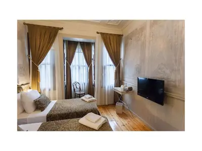 a bedroom with a bed and a flat screen tv at Hotel Troya Balat in Istanbul