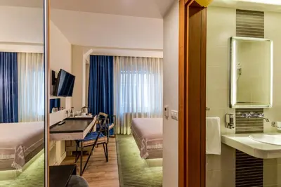 a hotel room with a sink and a bedroom at Parkhouse Hotel & Spa in Istanbul