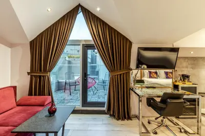 a living room with a red couch and a desk at Parkhouse Hotel & Spa in Istanbul