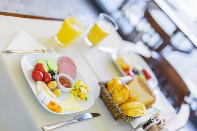 a table with two plates of food and two glasses of beer at Hotellino Istanbul in Istanbul