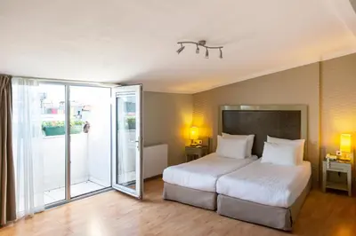a bedroom with a white bed and a sliding glass door at Hotellino Istanbul in Istanbul
