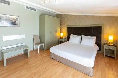 a bedroom with a large white bed and a desk at Hotellino Istanbul in Istanbul