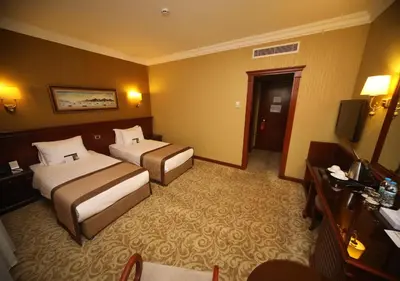 a hotel room with two beds and a television at Bilek Istanbul Hotel in Istanbul