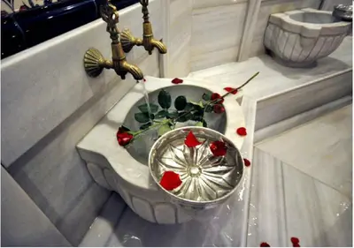 a vase with roses in it on a table at Bilek Istanbul Hotel in Istanbul