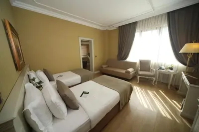 a hotel room with two beds and a couch at Bilek Istanbul Hotel in Istanbul