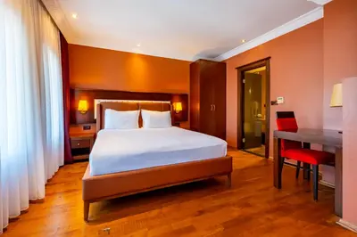 a bedroom with a bed and a desk and a table at Mangana Konak Hotel in Istanbul