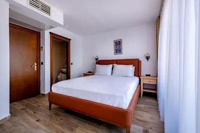 a bedroom with a large bed and a wooden floor at Mangana Konak Hotel in Istanbul
