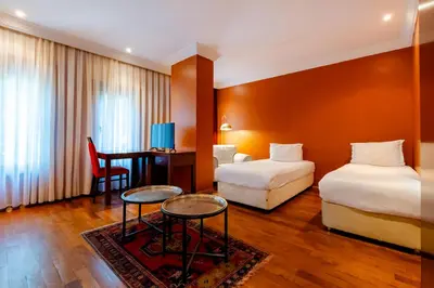 a hotel room with two beds and a desk at Mangana Konak Hotel in Istanbul