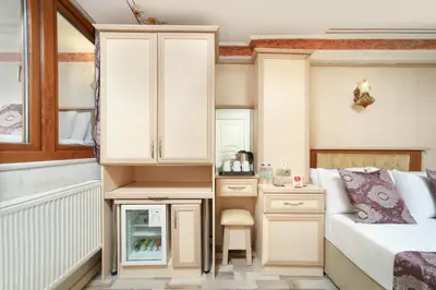 a small bedroom with a bed and a desk at Aldem Hotel in Istanbul