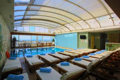 a swimming pool with tables and chairs in a building at Zagreb Hotel in Istanbul