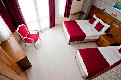 a hotel room with two beds and a chair at Artefes Hotel Old City in Istanbul