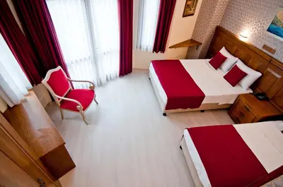 a hotel room with two beds and a chair at Artefes Hotel Old City in Istanbul