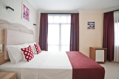 a bedroom with a large white bed with red and white pillows at Artefes Hotel Old City in Istanbul