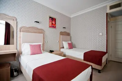 a hotel room with two beds with red and white sheets at Artefes Hotel Old City in Istanbul
