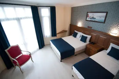 a hotel room with two beds and a chair at Artefes Hotel Old City in Istanbul