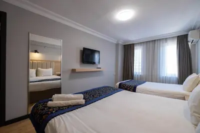 a hotel room with two beds and a mirror at Berr Hotel in Istanbul