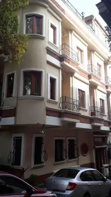 a large building with cars parked in front of it at Berce Apartments in Istanbul