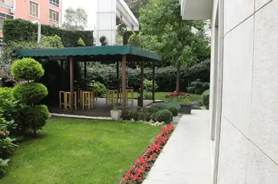 a garden with a gazebo with chairs and flowers at Agaoğlu My City Hotel Istanbul in Istanbul