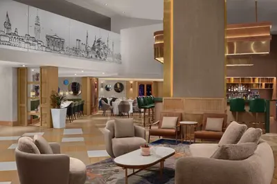 a lobby with chairs and tables and a bar at Delta Hotels Istanbul West in Istanbul