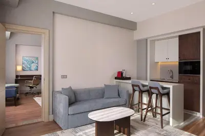 a living room with a couch and a kitchen at Delta Hotels Istanbul West in Istanbul