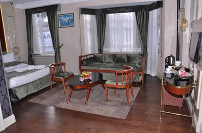 a living room with a couch and a table and chairs at Taksim Star Hotel in Istanbul