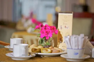 a table with plates of food and a vase with flowers at Taksim Star Hotel in Istanbul