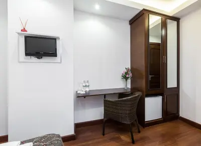 a room with a tv and a chair and a mirror at Buyukada Comfort OTEL in Buyukada