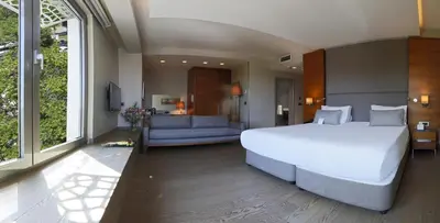 a bedroom with a large white bed and a couch at Hotel Arcadia Blue Istanbul in Istanbul