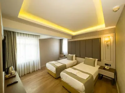 a hotel room with two beds and a window at Martinenz Hotel in Istanbul