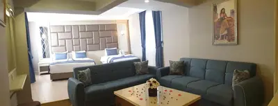 a living room with a couch and a room with two beds at Martinenz Hotel in Istanbul