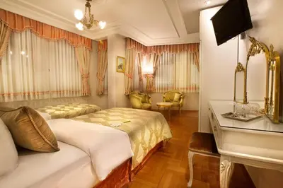 a hotel room with two beds and a desk at Valide Sultan Konagi in Istanbul