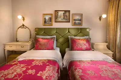 a bedroom with two beds and a mirror at Valide Sultan Konagi in Istanbul