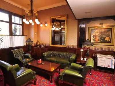 a living room with leather furniture and a chandelier at Germir Palas Hotel - Special Class in Istanbul