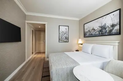 a bedroom with a white bed and a flat screen tv at Elite World Comfy Istanbul Taksim in Istanbul
