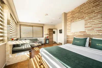 a bedroom with a large bed and a living room at The Pera Hotel in Istanbul