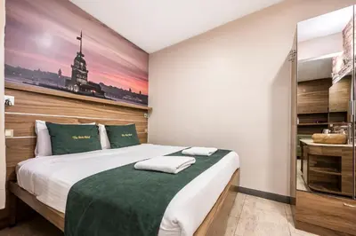 a bedroom with a large bed with a green blanket at The Pera Hotel in Istanbul