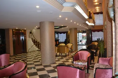 a lobby with pink chairs and a checkerboard floor at Tayhan Hotel in Istanbul