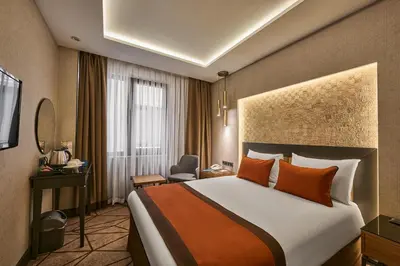a hotel room with a large bed and a chair at Grand Hotel Gulsoy Old City in Istanbul